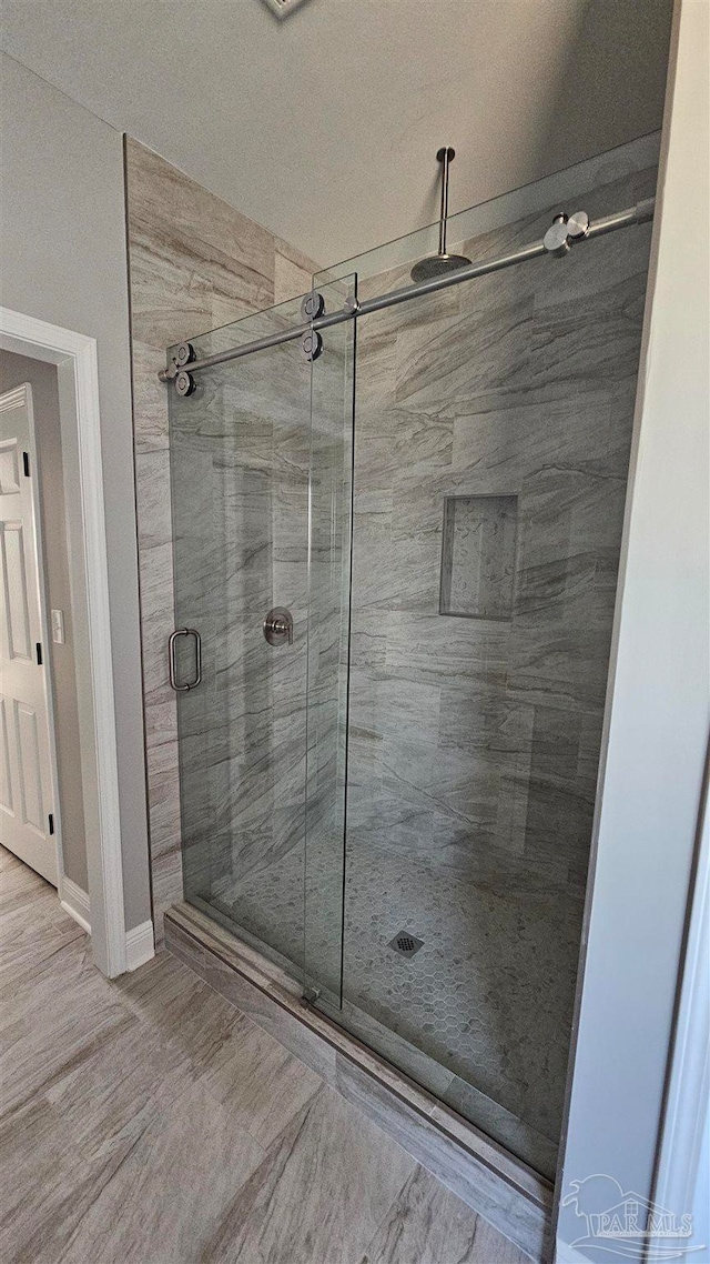 bathroom featuring wood-type flooring and an enclosed shower