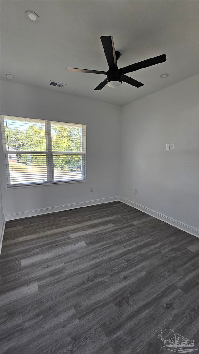 empty room with ceiling fan, dark hardwood / wood-style flooring, and plenty of natural light