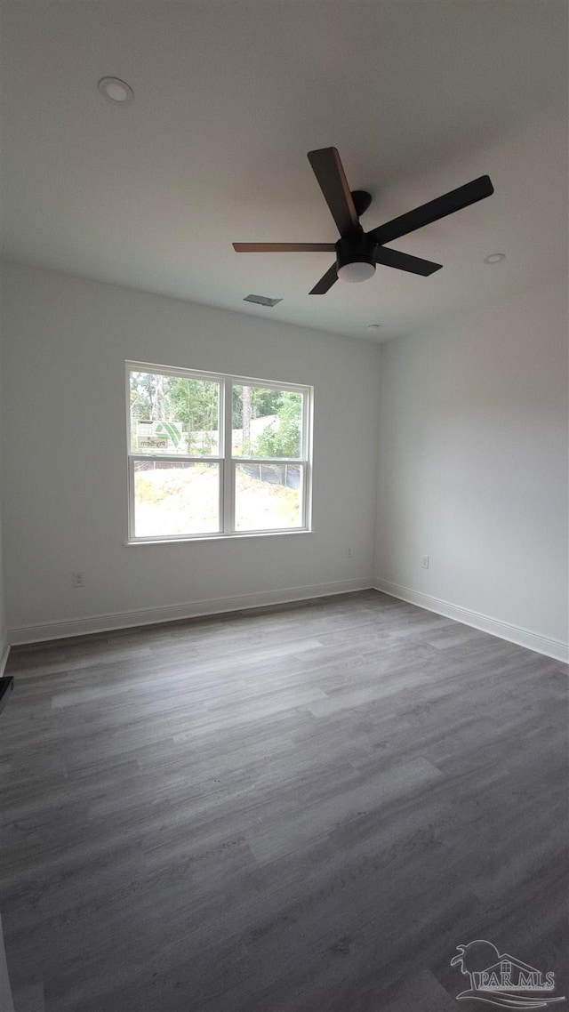 unfurnished room featuring dark wood-type flooring and ceiling fan