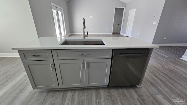 kitchen with gray cabinets, dark wood-type flooring, stainless steel dishwasher, and sink