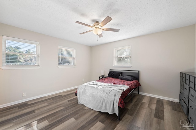 bedroom featuring dark wood-type flooring, ceiling fan, and a textured ceiling