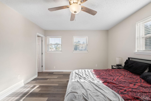 bedroom featuring ceiling fan, dark hardwood / wood-style floors, and a textured ceiling