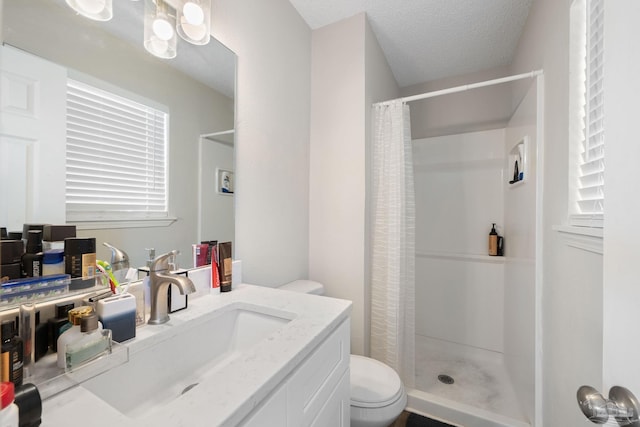 bathroom featuring a textured ceiling, toilet, walk in shower, and vanity