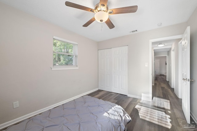 bedroom featuring ceiling fan, dark wood-type flooring, and a closet