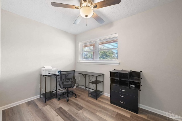 home office featuring ceiling fan, wood-type flooring, and a textured ceiling