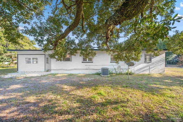 back of house featuring cooling unit and a yard