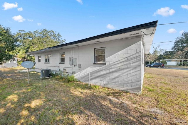 rear view of house with a lawn and central AC unit