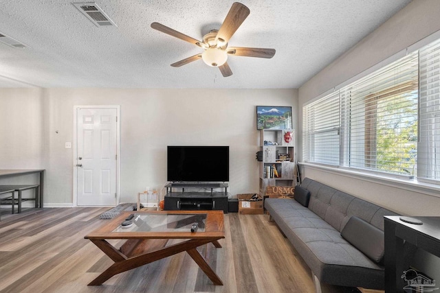 living room featuring a textured ceiling, ceiling fan, and hardwood / wood-style floors