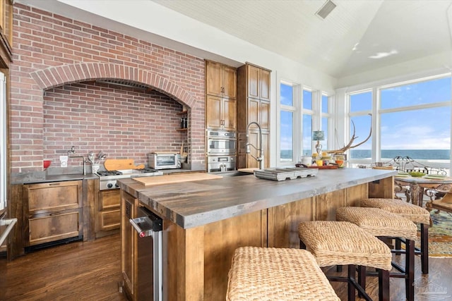 1220 State Highway 180, Gulf Shores, AL 36542 - kitchen with wooden counters, dark wood-style flooring, a sink, brown cabinets, and a center island