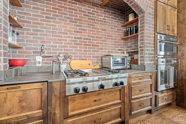 1220 State Highway 180, Gulf Shores, AL 36542 - kitchen featuring open shelves, stainless steel appliances, brick wall, and brown cabinetry
