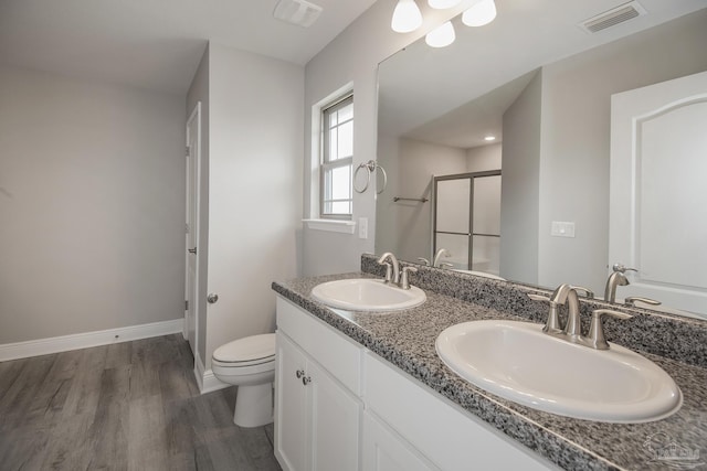 3620 Ranch Dr, Crestview, FL 32539 - full bath featuring wood finished floors, a stall shower, baseboards, toilet, and double vanity