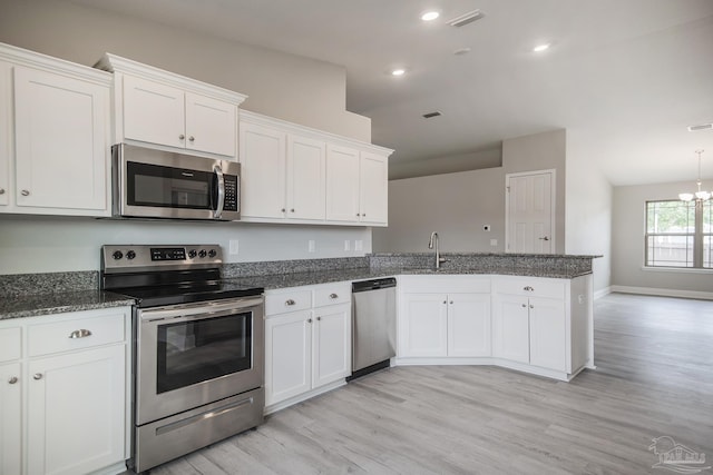 3620 Ranch Dr, Crestview, FL 32539 - kitchen with appliances with stainless steel finishes, a sink, a peninsula, white cabinetry, and light wood finished floors
