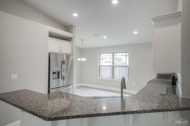 3620 Ranch Dr, Crestview, FL 32539 - kitchen with stainless steel fridge with ice dispenser, a sink, dark stone counters, a peninsula, and white cabinetry