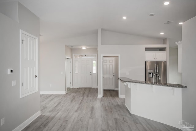 3620 Ranch Dr, Crestview, FL 32539 - kitchen featuring stainless steel fridge with ice dispenser, a breakfast bar area, baseboards, dark stone counters, and white cabinets