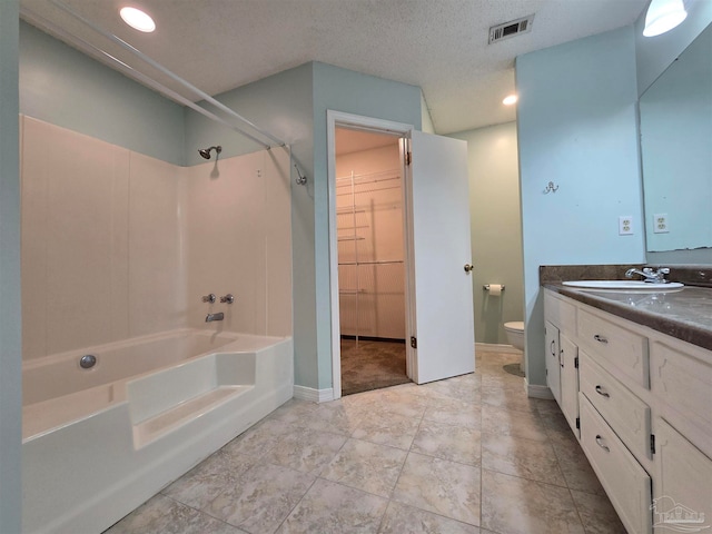 full bathroom featuring toilet, a textured ceiling, vanity, and shower / bathtub combination