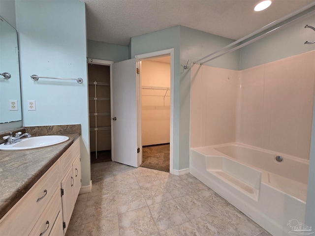 bathroom with vanity, bathtub / shower combination, and a textured ceiling