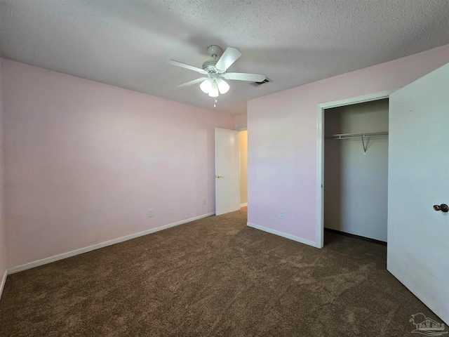 unfurnished bedroom featuring a closet, ceiling fan, a textured ceiling, and dark carpet