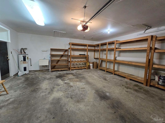 garage featuring a garage door opener, electric water heater, and sink