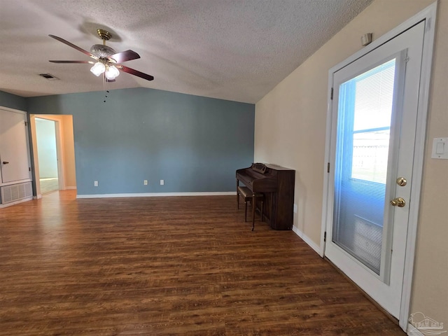 unfurnished living room with ceiling fan, a textured ceiling, vaulted ceiling, and dark hardwood / wood-style flooring