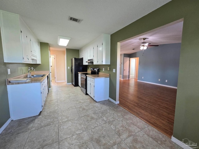 kitchen featuring appliances with stainless steel finishes, white cabinetry, a textured ceiling, light wood-type flooring, and sink