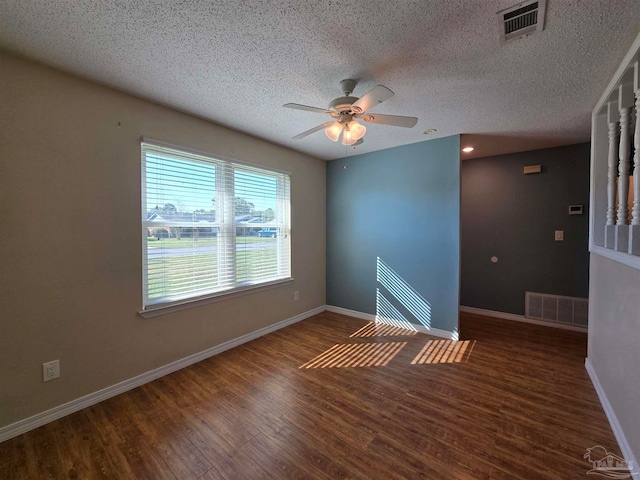 spare room with dark wood-type flooring, ceiling fan, and a textured ceiling