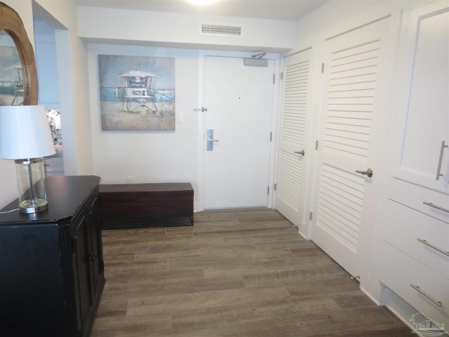 hall featuring dark wood-style floors and visible vents