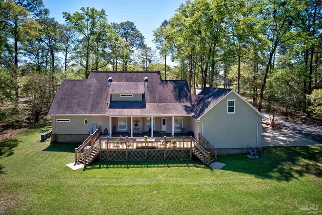 back of property featuring a wooden deck, a yard, and central AC