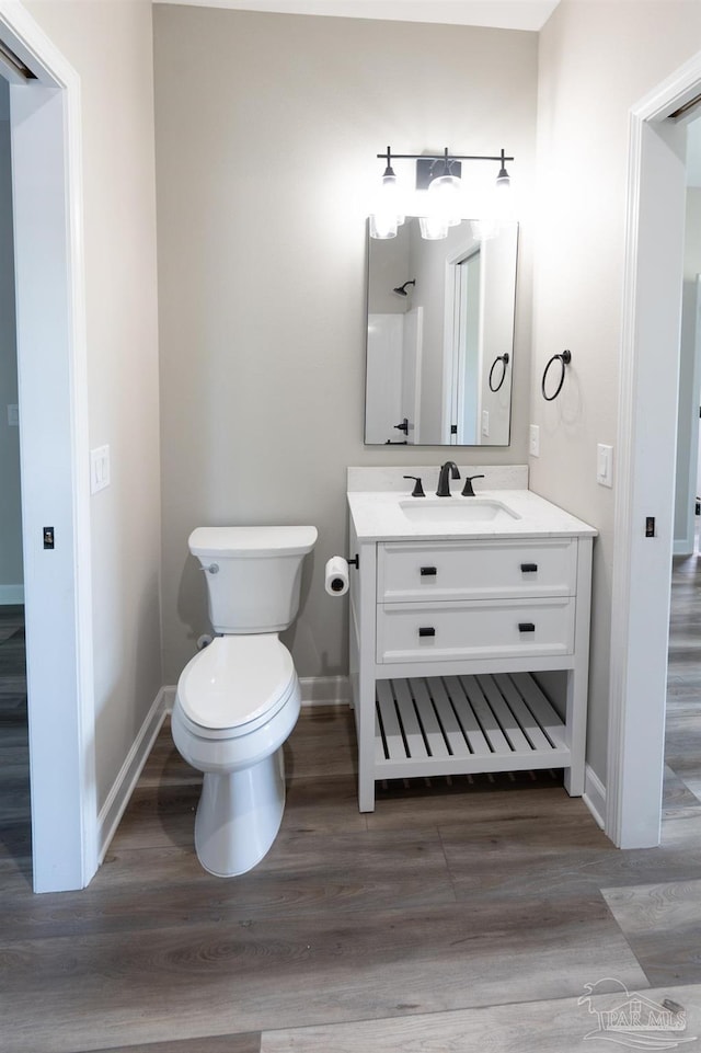 9901 Raymar St Unit A, Pensacola, FL 32534 - bathroom featuring toilet, vanity, wood finished floors, and baseboards