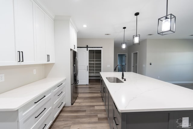 9901 Raymar St Unit A, Pensacola, FL 32534 - kitchen with stainless steel fridge with ice dispenser, a large island with sink, a barn door, a sink, and light wood finished floors