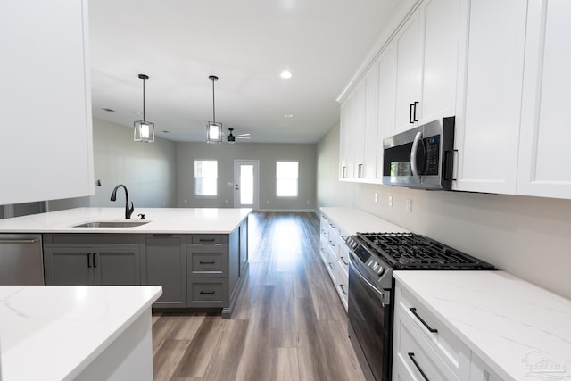 9901 Raymar St Unit A, Pensacola, FL 32534 - kitchen featuring open floor plan, gray cabinetry, appliances with stainless steel finishes, a sink, and wood finished floors