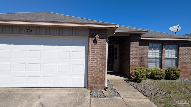 view of front of property featuring concrete driveway, brick siding, and roof with shingles