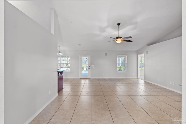 unfurnished living room with lofted ceiling, plenty of natural light, and light tile patterned flooring