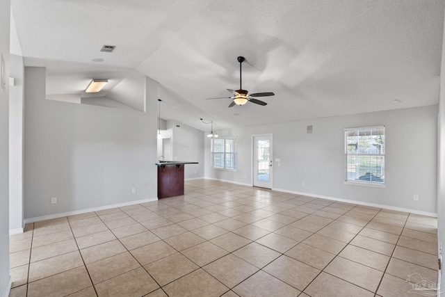 unfurnished living room featuring light tile patterned floors, a textured ceiling, a ceiling fan, and a healthy amount of sunlight