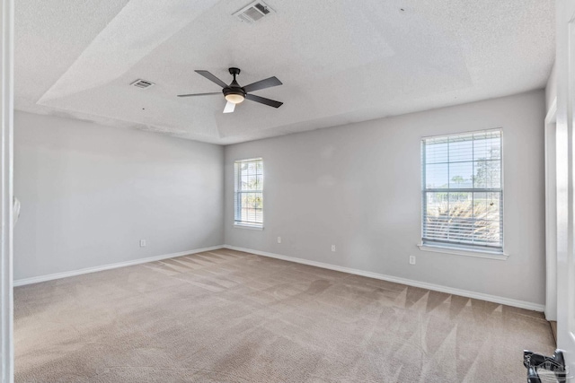 empty room featuring visible vents, light carpet, and baseboards