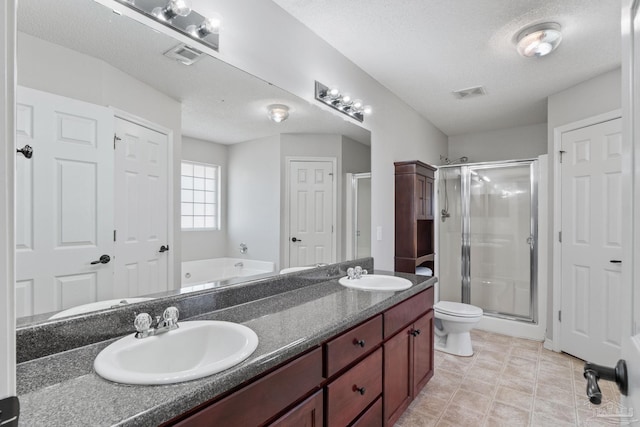 bathroom featuring a stall shower, visible vents, a sink, and double vanity