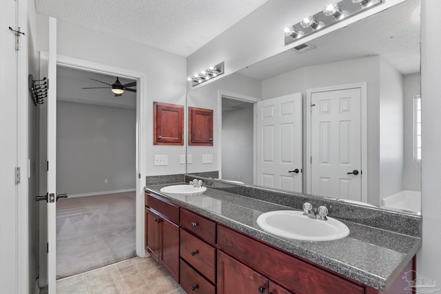 bathroom with a textured ceiling, a sink, visible vents, a ceiling fan, and double vanity