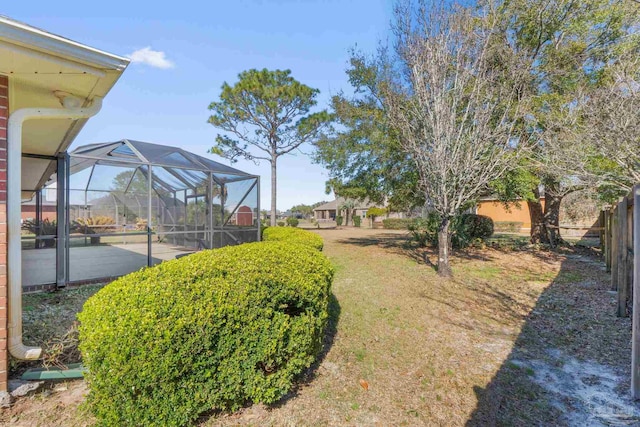 view of yard featuring a lanai and fence