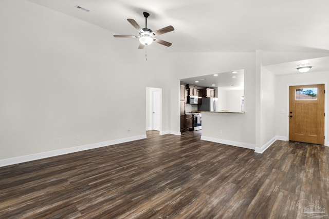 unfurnished living room with dark wood-type flooring, visible vents, vaulted ceiling, and baseboards