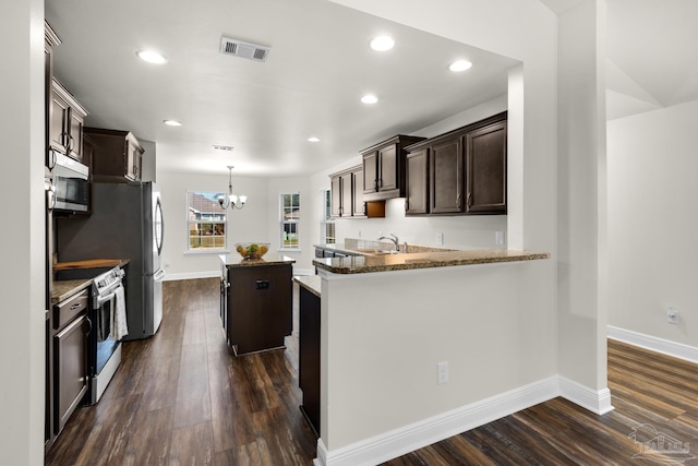 kitchen with electric range, visible vents, dark wood finished floors, and dark brown cabinets