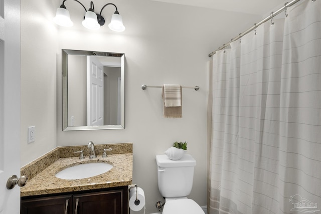 bathroom with curtained shower, vanity, and toilet