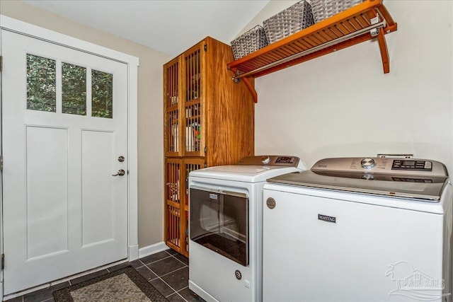 laundry area with dark tile patterned flooring and washer and clothes dryer