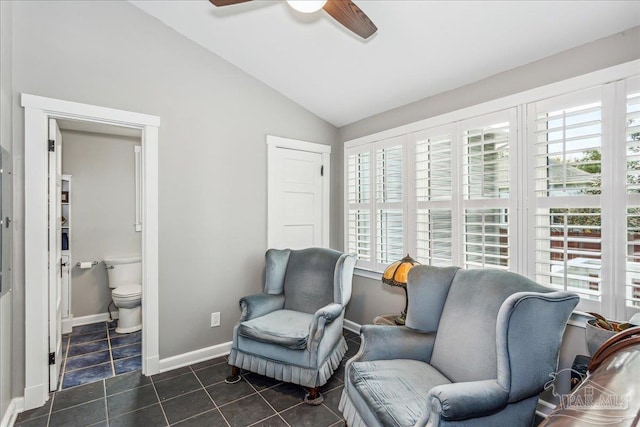 sitting room with ceiling fan, vaulted ceiling, and dark tile patterned floors