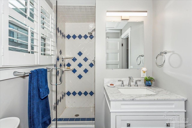 bathroom with a shower with door and vanity