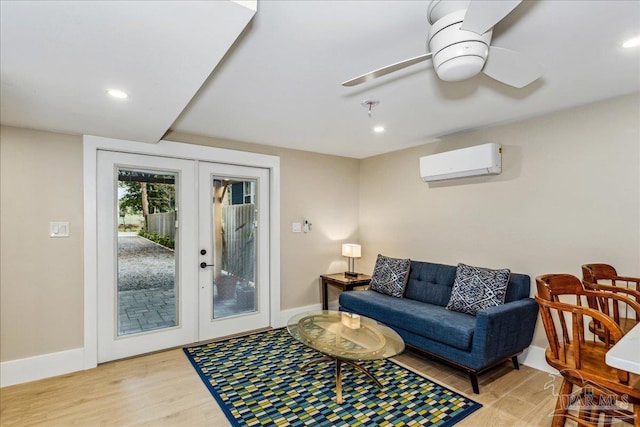 living room featuring ceiling fan, light hardwood / wood-style flooring, french doors, and a wall mounted AC