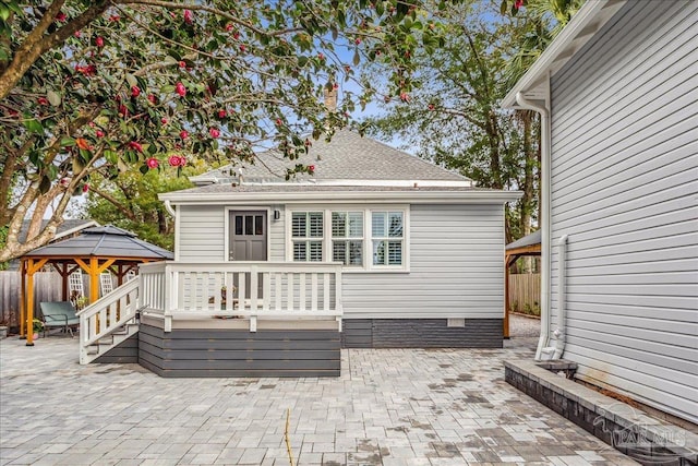 rear view of house featuring a gazebo, a wooden deck, and a patio area