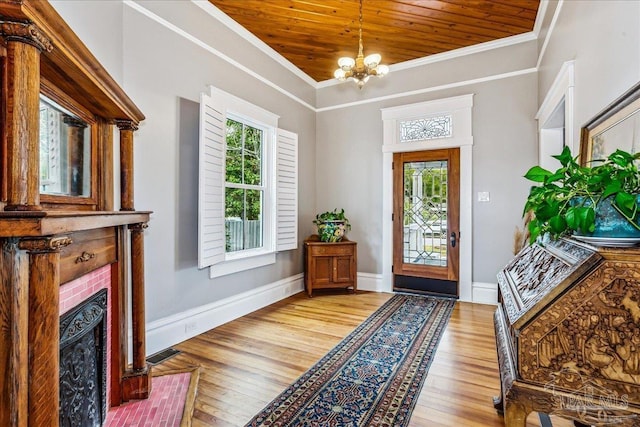 foyer entrance with a wealth of natural light, wooden ceiling, an inviting chandelier, and light hardwood / wood-style flooring