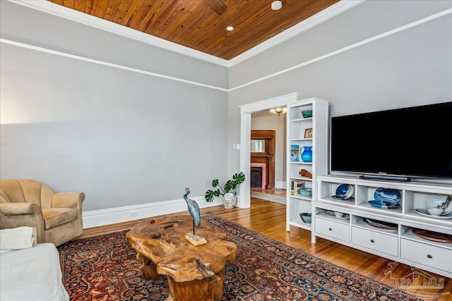 living room featuring hardwood / wood-style flooring, a fireplace, crown molding, and wooden ceiling