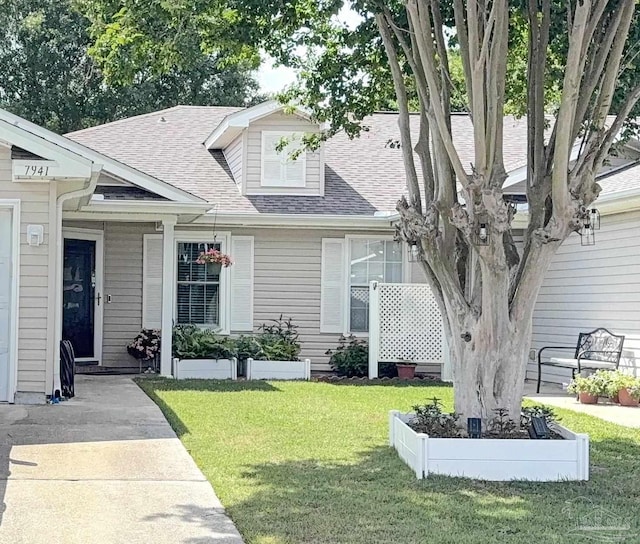 view of front of house featuring a shingled roof and a front lawn
