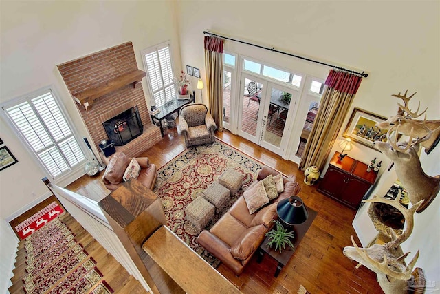607 Goodwill Cir, Silas, AL 36919 - living area featuring a high ceiling, hardwood / wood-style floors, a brick fireplace, and french doors