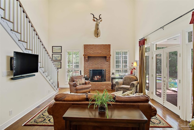 607 Goodwill Cir, Silas, AL 36919 - living area with a high ceiling, wood-type flooring, stairs, a fireplace, and french doors